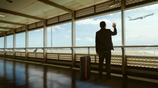 young businessman waving good bye at airport