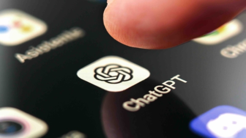 Oviedo, Spain - December, 13, 2023: ChatGPT app icon on smartphone screen with pushing finger. Artificial intelligence chatbot service on mobile phone. Macro shot