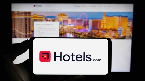 Stuttgart, Germany - 08-18-2023: Person holding mobile phone with logo of American hotel booking company Hotels.com LP on screen in front of web page. Focus on phone display.